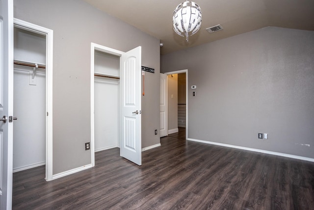 unfurnished bedroom with multiple closets and dark hardwood / wood-style floors