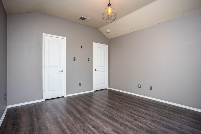 spare room with vaulted ceiling and dark hardwood / wood-style flooring