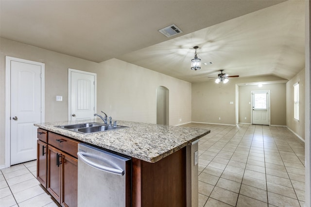 kitchen featuring an island with sink, sink, stainless steel dishwasher, and decorative light fixtures