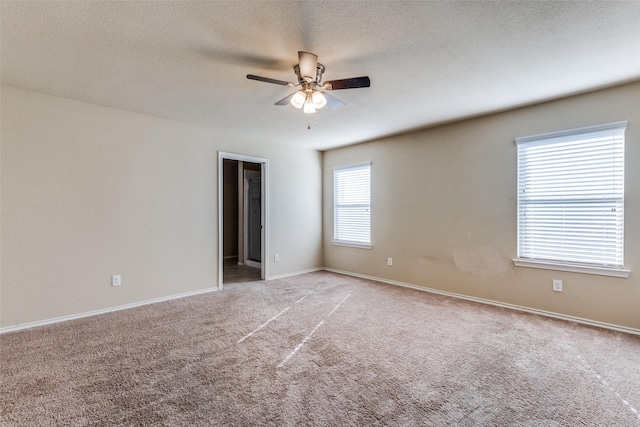 empty room featuring a textured ceiling, carpet floors, and ceiling fan