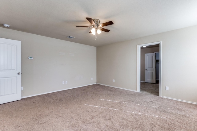 empty room featuring ceiling fan and light colored carpet