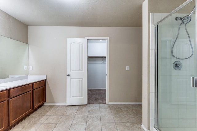 bathroom featuring tile patterned flooring, vanity, a textured ceiling, and a shower with shower door