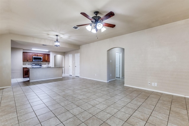 unfurnished living room featuring light tile patterned floors and ceiling fan