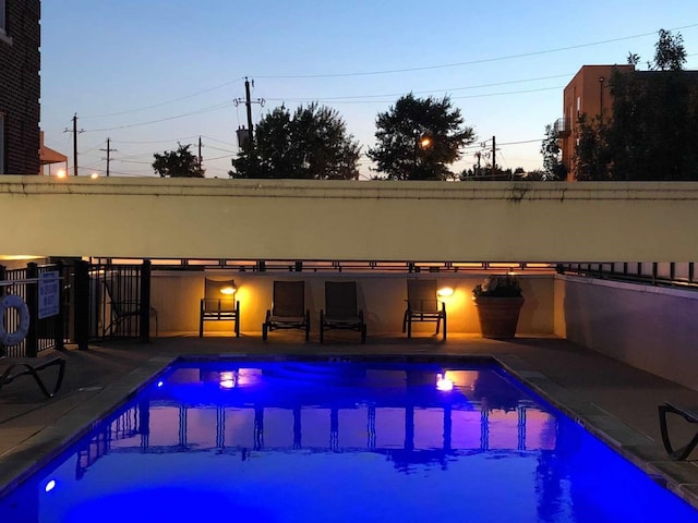 pool at dusk featuring a patio