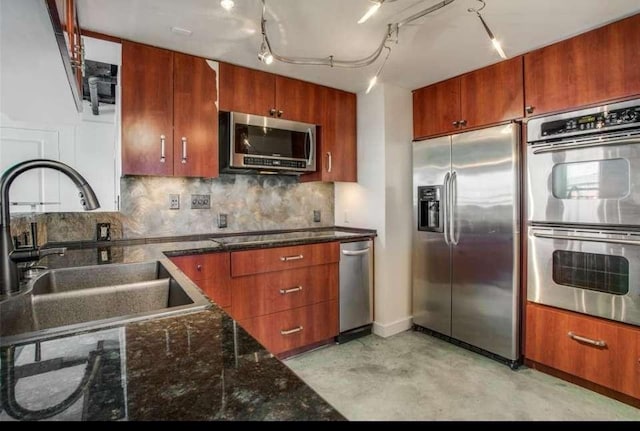 kitchen with stainless steel appliances, tasteful backsplash, sink, and dark stone countertops