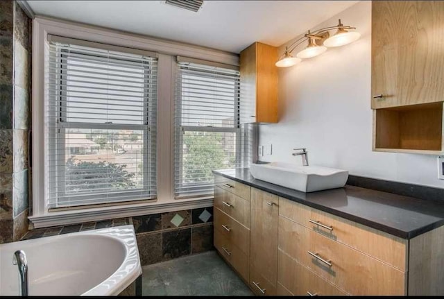 bathroom with vanity and a bath