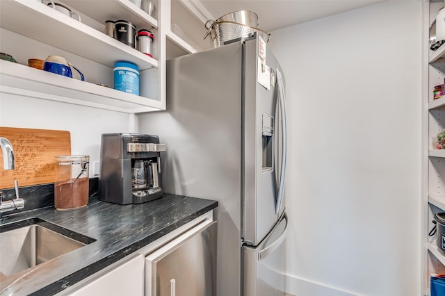 kitchen with stainless steel refrigerator with ice dispenser, sink, and white cabinets