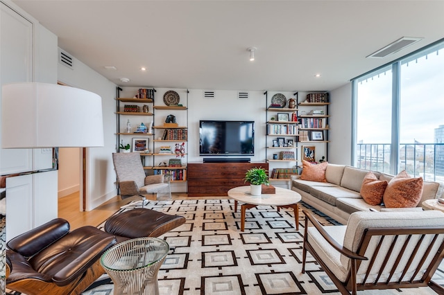 living room featuring floor to ceiling windows and light hardwood / wood-style flooring