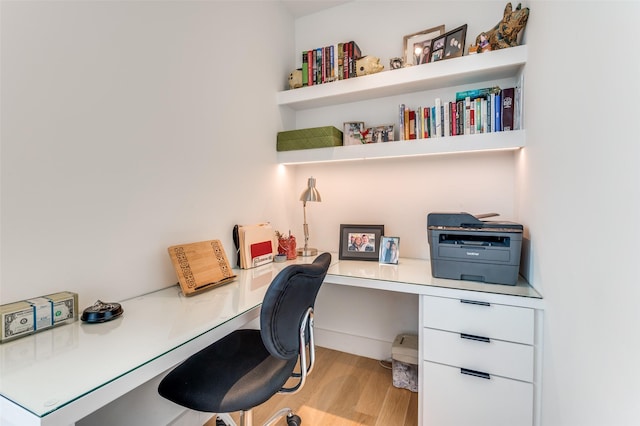 office space with light hardwood / wood-style flooring and built in desk