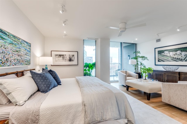 bedroom featuring expansive windows, ceiling fan, light hardwood / wood-style floors, and access to outside