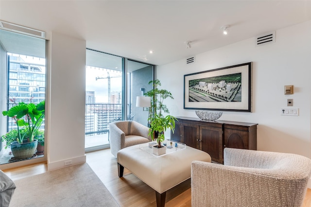 living area with light hardwood / wood-style floors and floor to ceiling windows