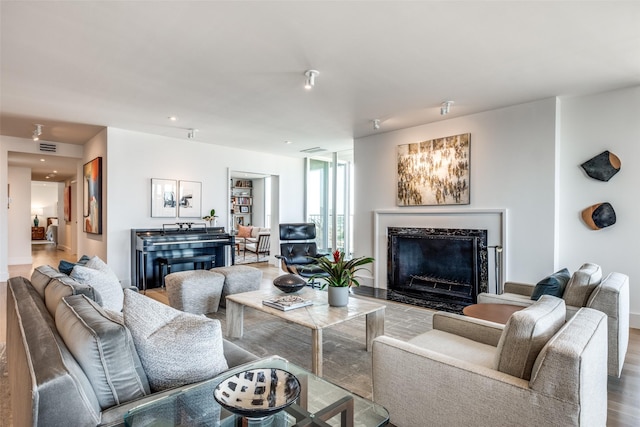 living room with hardwood / wood-style floors and a high end fireplace