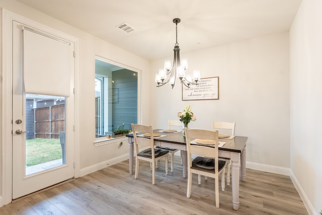 dining room featuring an inviting chandelier and light hardwood / wood-style flooring