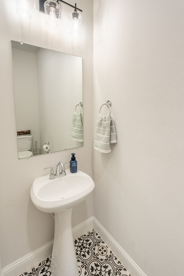 bathroom with toilet and tile patterned flooring