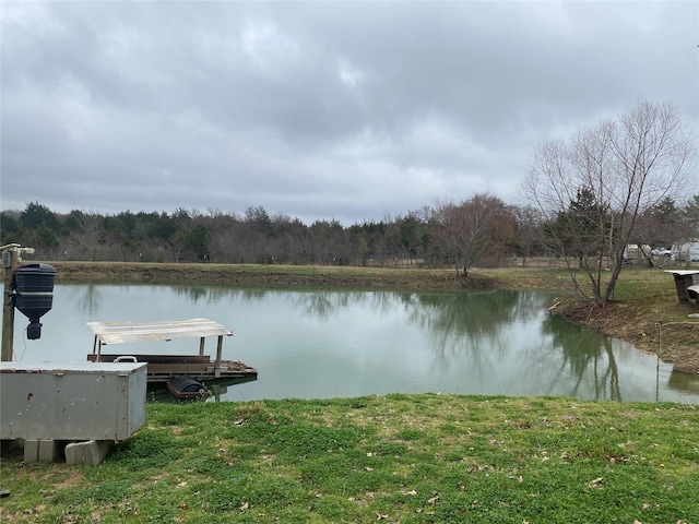 view of dock with a water view and a forest view