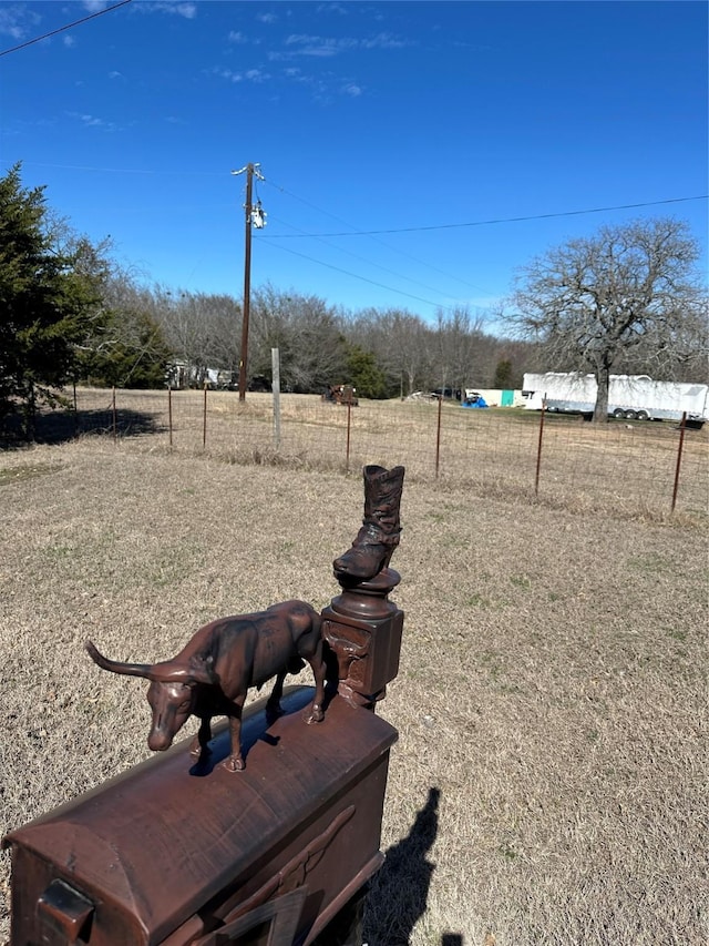 view of yard with a rural view and fence