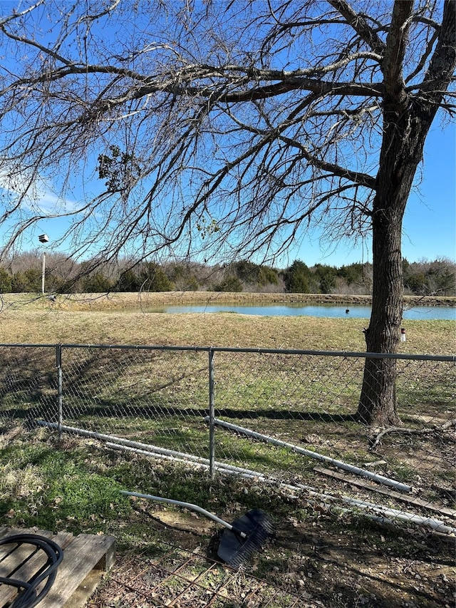view of yard with a water view and fence