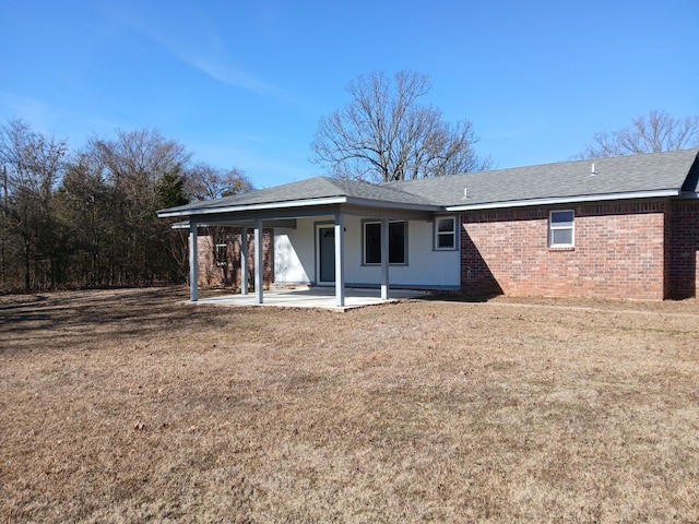 rear view of property with a lawn and a patio area