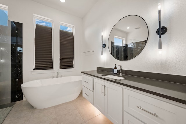 bathroom with vanity, tile patterned flooring, and plus walk in shower