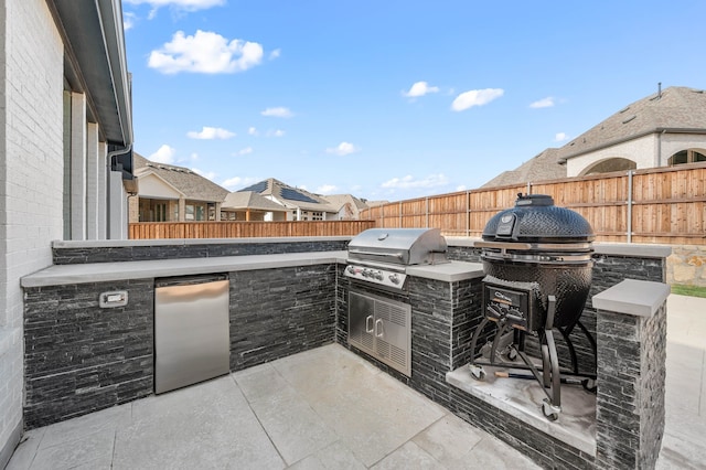 view of patio with area for grilling and a grill