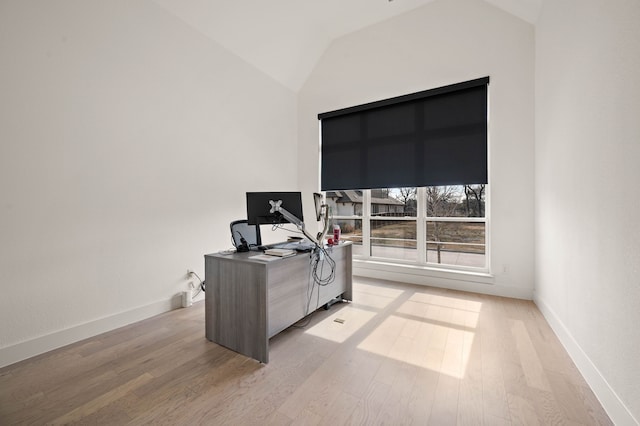 office with lofted ceiling and light wood-type flooring