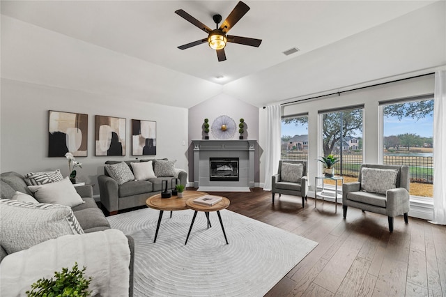 5010 Plantation Ln, Frisco, TX 75035 - living room with vaulted ceiling, ceiling fan, dark wood-type flooring, a glass covered fireplace, and baseboards