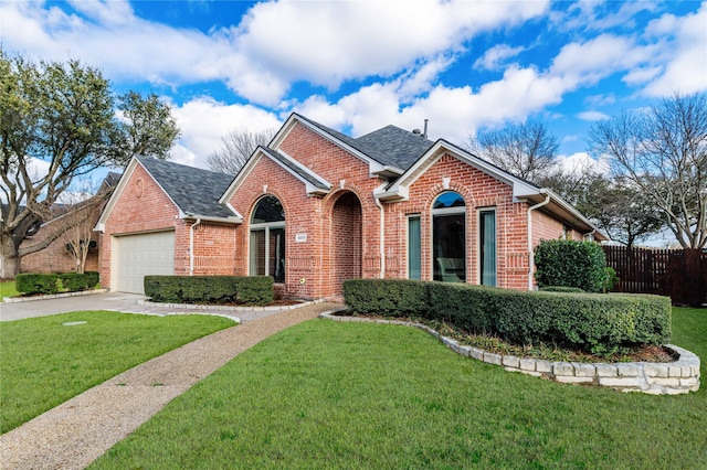 view of front facade featuring brick siding, a garage, a front yard, and fence