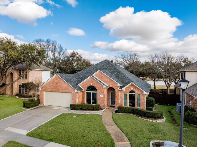 view of front of house featuring brick siding, a shingled roof, a front yard, a garage, and driveway