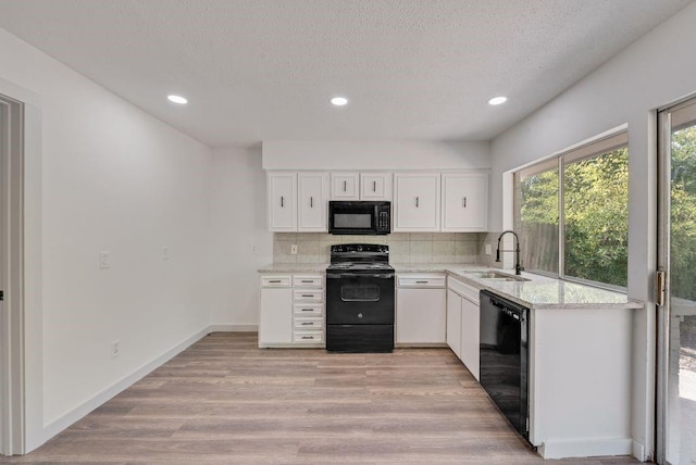 kitchen with sink, white cabinetry, tasteful backsplash, light hardwood / wood-style flooring, and black appliances