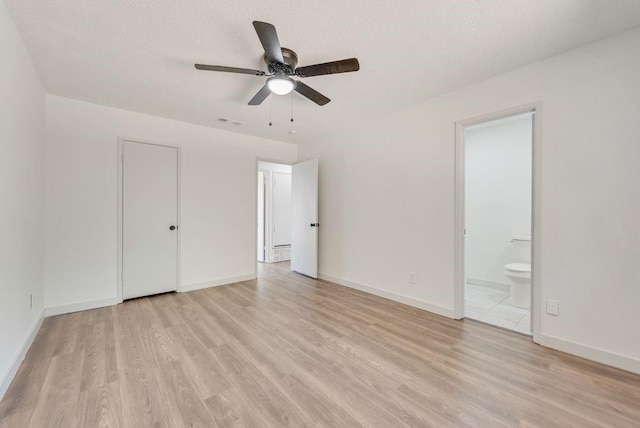 unfurnished bedroom with ceiling fan, connected bathroom, a textured ceiling, and light hardwood / wood-style floors