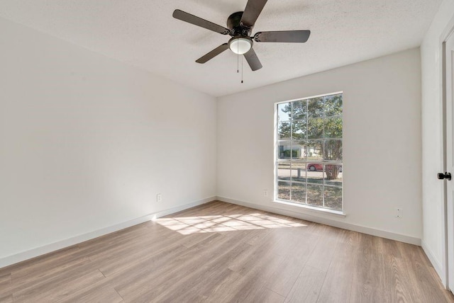 empty room with ceiling fan, light hardwood / wood-style floors, and a textured ceiling