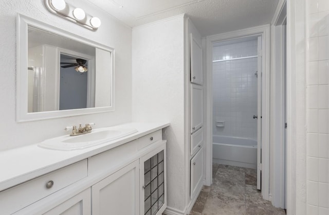 bathroom featuring vanity, tiled shower / bath combo, and a textured ceiling