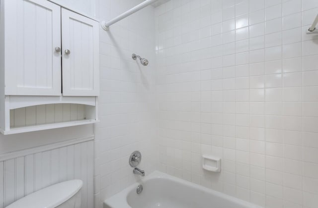 bathroom featuring toilet and tiled shower / bath