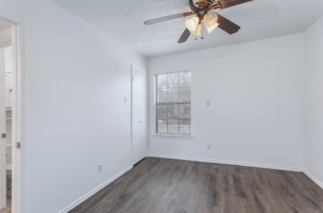 empty room featuring dark hardwood / wood-style flooring, ceiling fan, and a textured ceiling