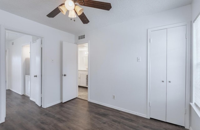 unfurnished bedroom featuring ceiling fan, dark wood-type flooring, a closet, and a textured ceiling