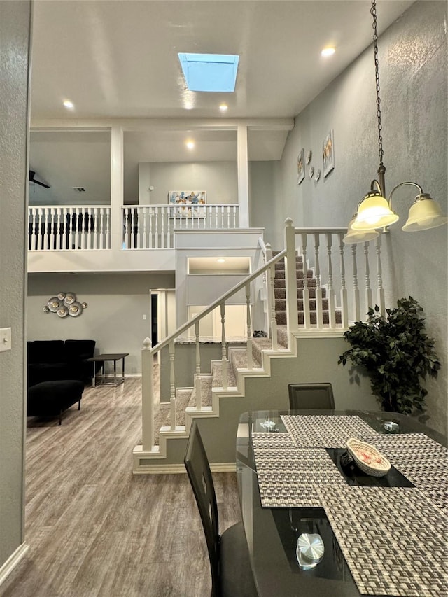 dining space featuring hardwood / wood-style flooring and a skylight