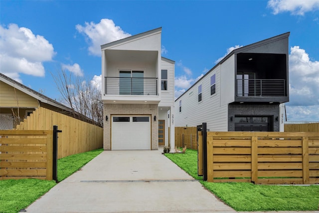 modern home featuring a garage, a balcony, and a front yard