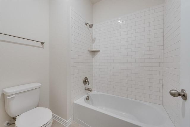 bathroom with tiled shower / bath combo and toilet