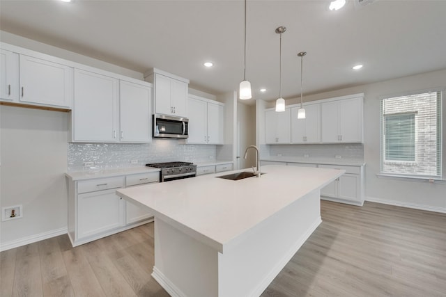 kitchen featuring appliances with stainless steel finishes, sink, and white cabinets