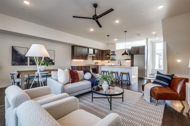 living room featuring dark wood-type flooring, a ceiling fan, and recessed lighting