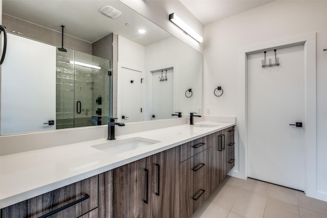 full bath with a shower stall, double vanity, and tile patterned floors