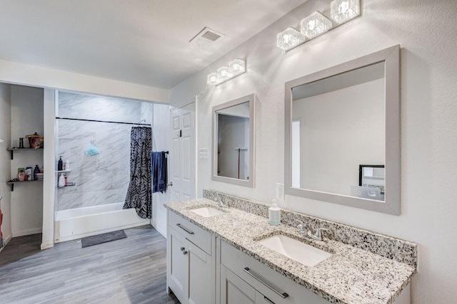 bathroom with vanity, wood-type flooring, and shower / tub combo