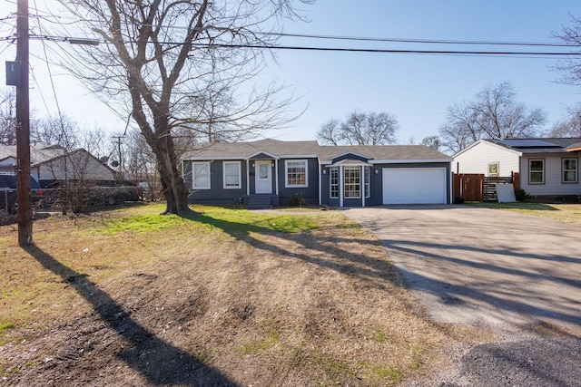 ranch-style house featuring a garage and a front lawn