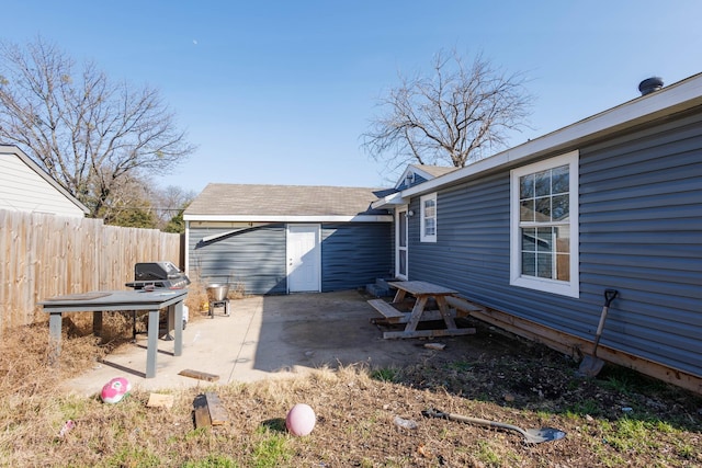 back of property featuring an outdoor structure and a patio