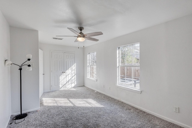 spare room featuring light carpet and ceiling fan