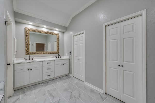 bathroom featuring vaulted ceiling, ornamental molding, and vanity