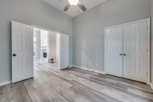 interior space with ceiling fan, a fireplace, and light wood-type flooring