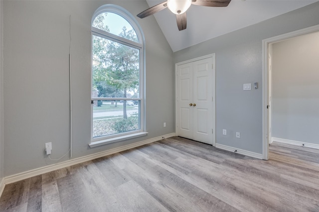 unfurnished room with ceiling fan, lofted ceiling, and light hardwood / wood-style floors