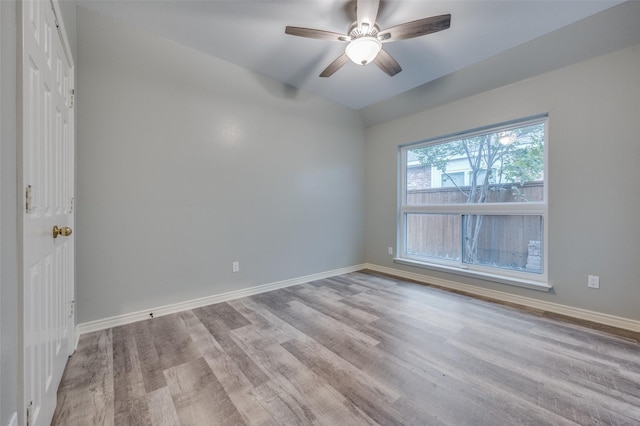 empty room featuring lofted ceiling, ceiling fan, and light wood-type flooring