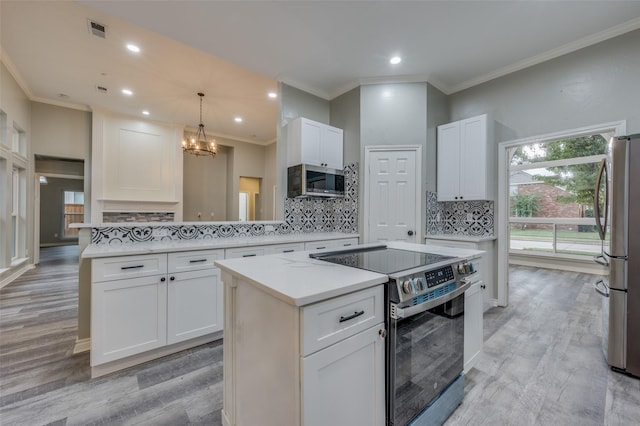 kitchen featuring white cabinetry, pendant lighting, stainless steel appliances, and a center island